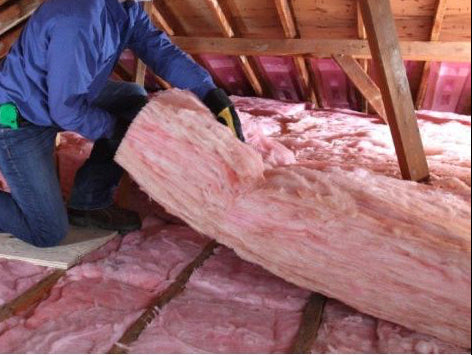 Installation of R49 unfaced fiberglass insulation batts in an attic.
