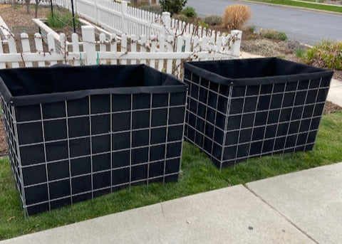 Two garden boxes on a grassy area near a sidewalk