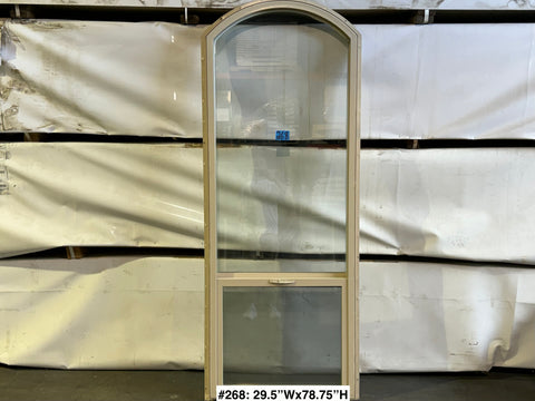 Beige vinyl-framed, used Amsco single hung window with arch top. 