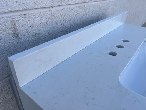 Backsplash detail on new quartz apron type lavatory vanity countertop. 