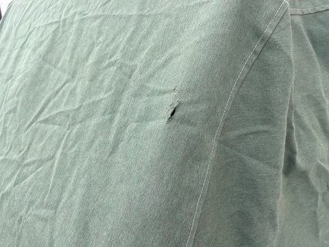 Green canvas grill cover with small hole. 