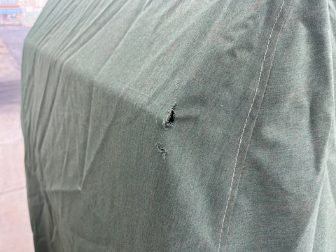 Small hole in green canvas grill cover. 