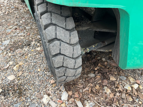 Left rear pneumatic tire & steering components on FG20 fork truck. 