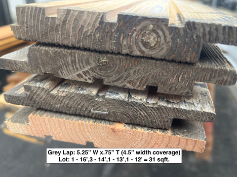 Close-up of ends of gray lap siding lot. 