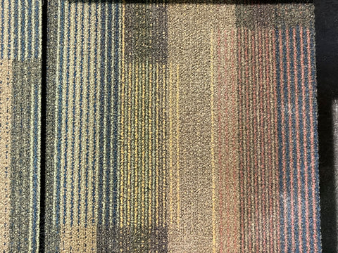 Close up of used, multicolor, 20", commercial carpet panels. 