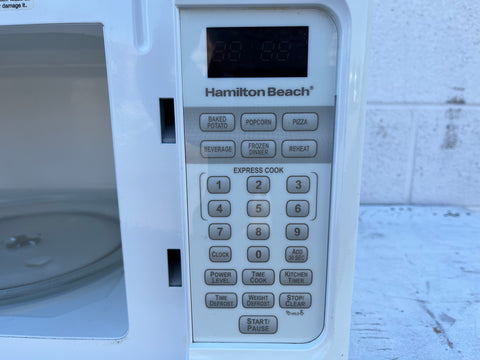 Close up of control panel of Hamilton Beach microwave oven featuring digital display and electronic buttons. 