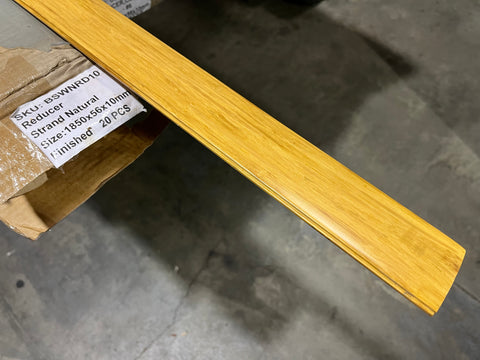 Overview of new, strand natural finished, solid wood floor reducer in original packaging with label. 