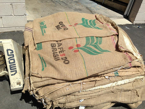Quantity view of burlap coffee bags. Material Resourcers repurposes materials from industrial & manufacturing companies. Bring us your waste, excess, non-recyclable, by-product, remnant, blemished, cancelled, and expired materials.